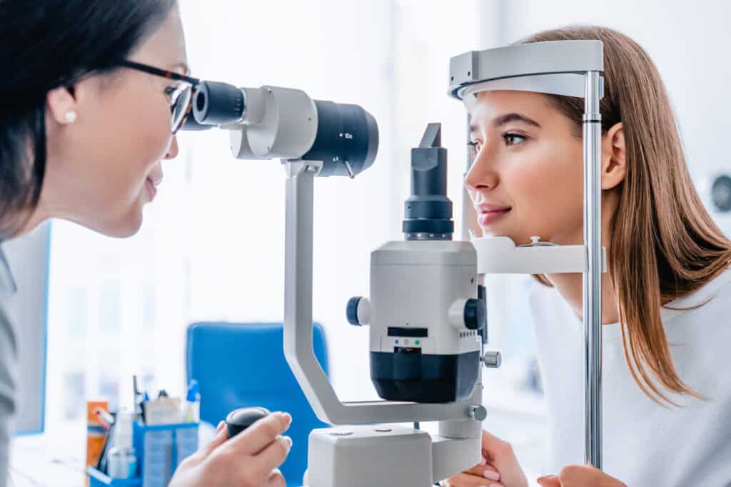 Side view shot of female doctor and patient in ophthalmology clinic Elmiron eye exam